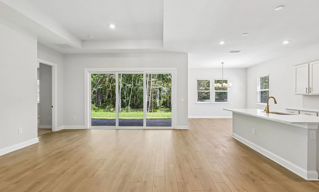 As you continue to the end of the foyer you are welcomed into the open concept living, kitchen and