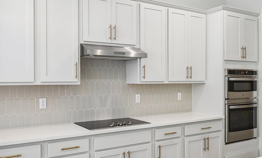 This kitchen offers a double stack microwave and oven, a vent hood and a flat top range all