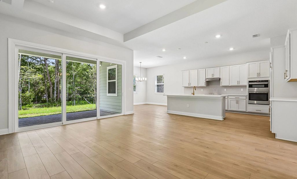 The family room opens up into the kitchen with a tray ceiling and a large sliding glass door