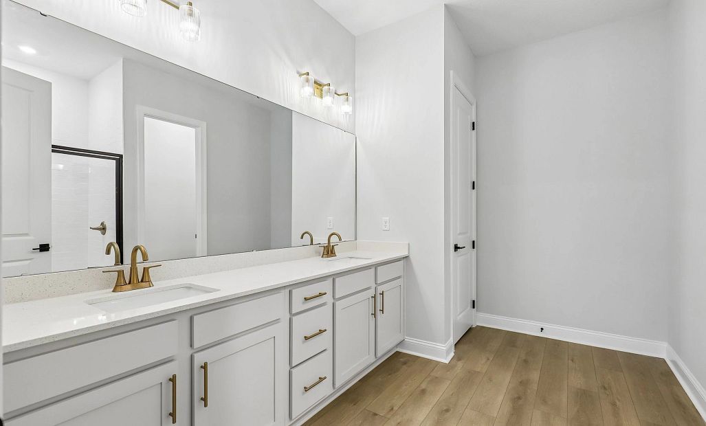 The primary bathroom has a double sink vanity and features aspects of AW Collection® Serene