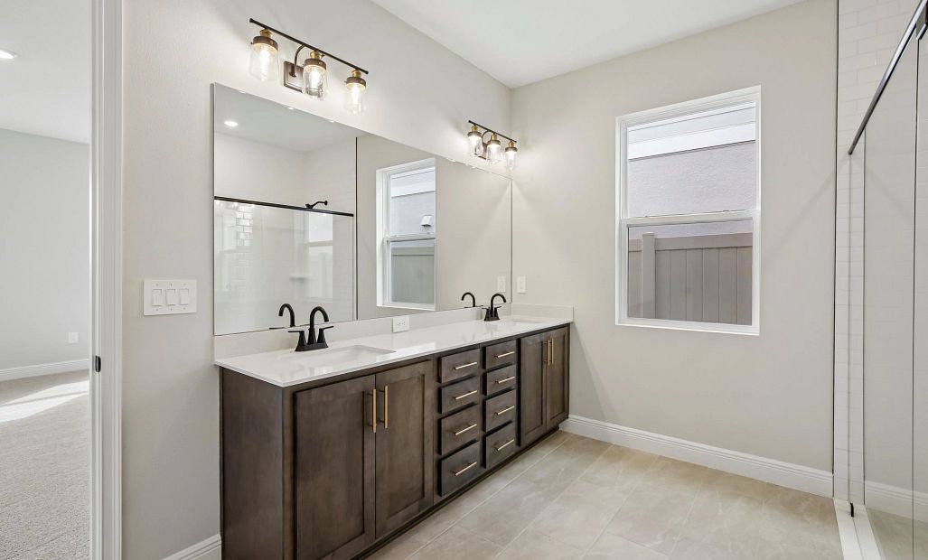 The primary bathroom features a double sink vanity and aspects of AW Collection® Oxford