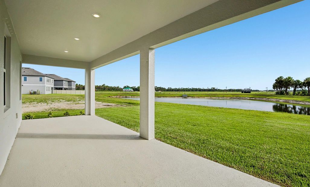 Stunning covered back lanai features views of the backyard pond