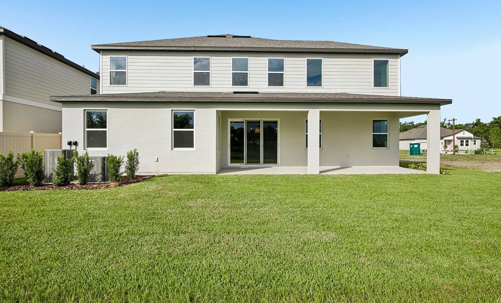 Back of the Amelia home features a large covered back lanai and a large sliding glass door