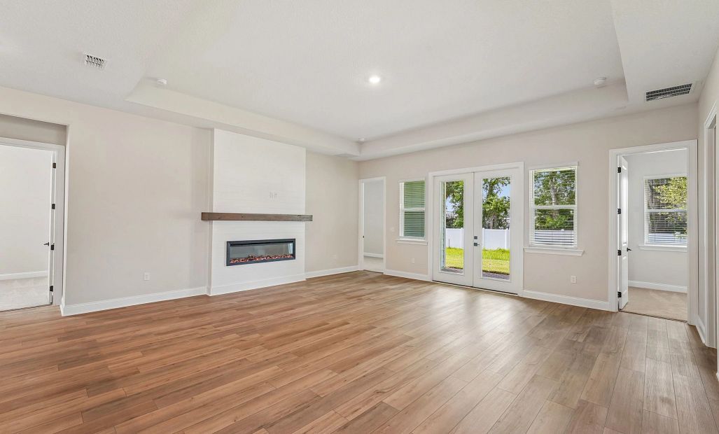 The family room has a tray ceiling and looks out on to the covered back lanai
