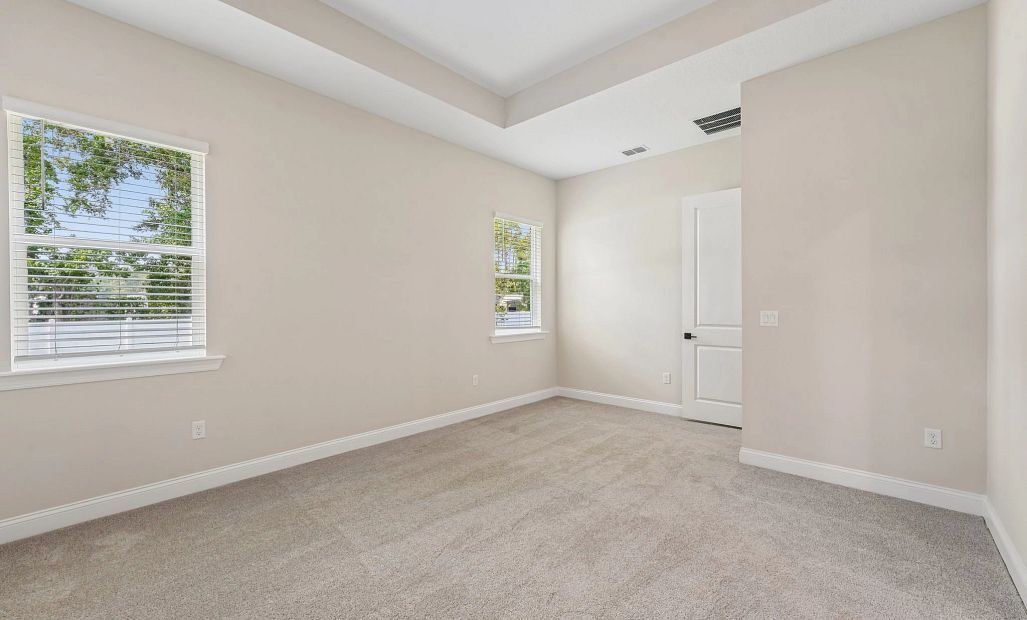 The primary bedroom features a tray ceiling