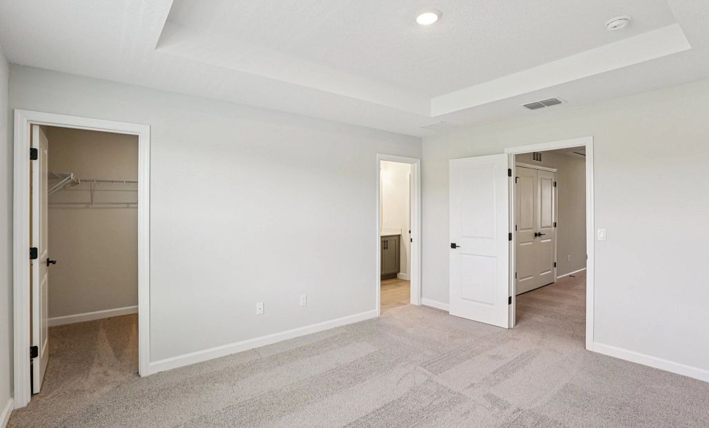 Primary bedroom features a large walk-in closet and spacious primary bathroom -  Representative