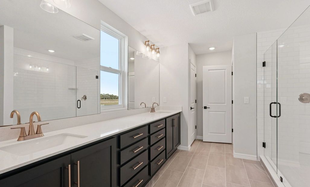 Spacious primary bathroom with a walk-in shower and enclosed water closet - representative image