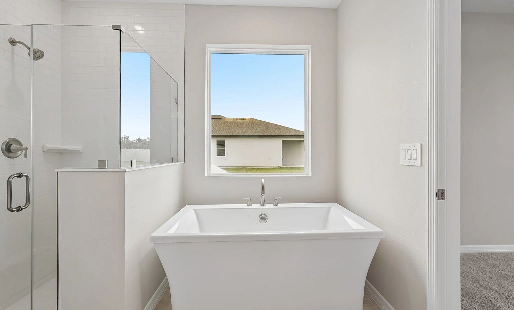 The primary bathroom features a stunning free standing tub