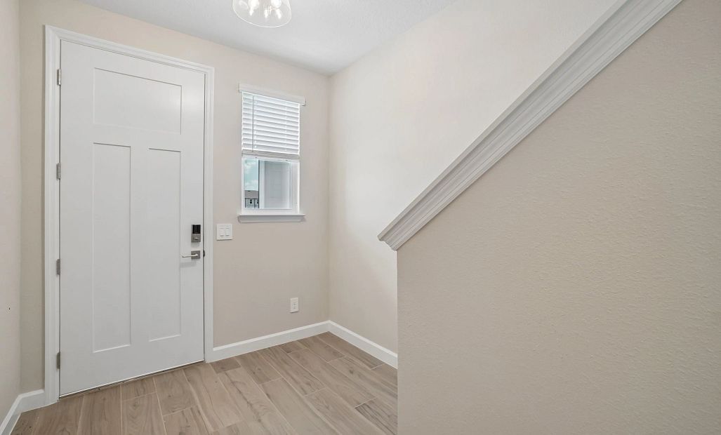 Foyer featuring a window next to the front door - Representative images and renderings are for