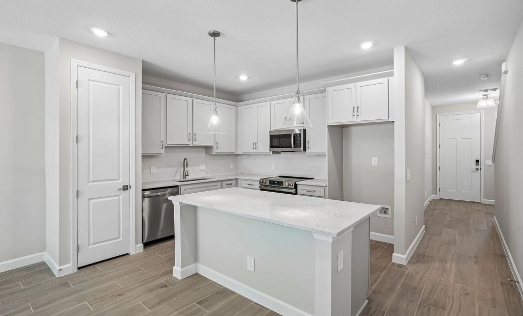 Spacious kitchen with a large island and pantry featuring AW Collection® Milan - Representative