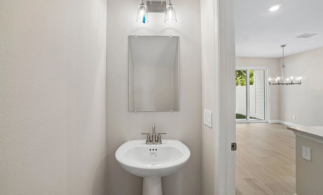 Half bathroom located off the kitchen on the first floor - Representative images and renderings are