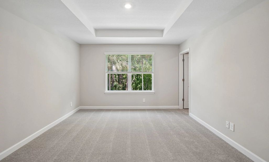 Primary bedroom featuring a tray ceiling and a double window - Representative images and renderings