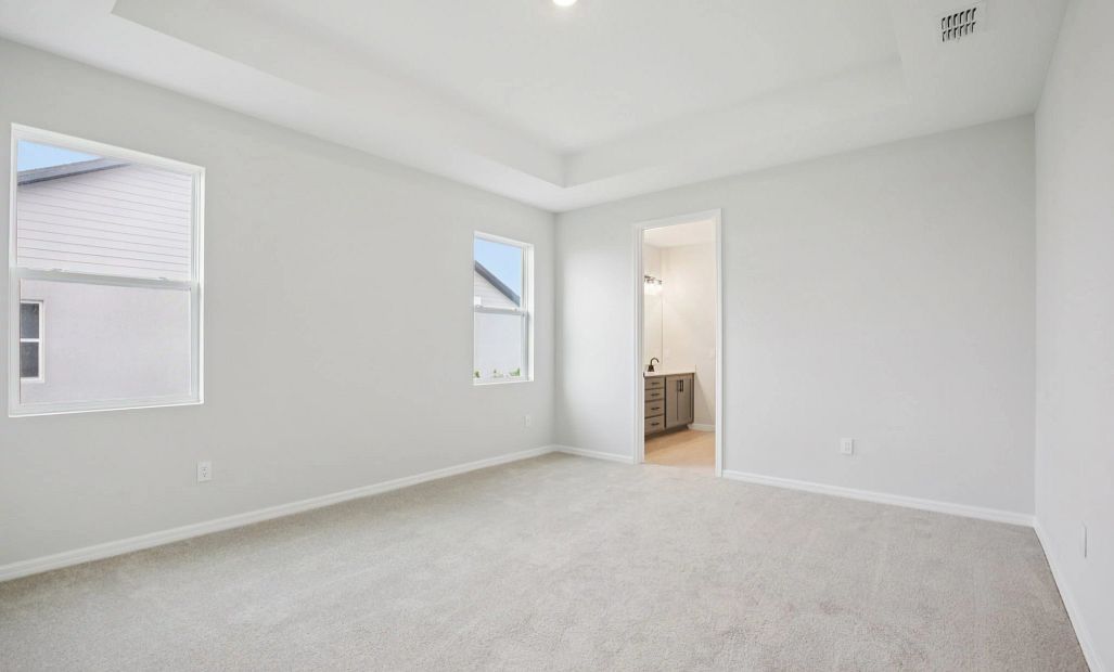 Primary bedroom featuring a tray ceiling - Representative images and renderings are for illustrative