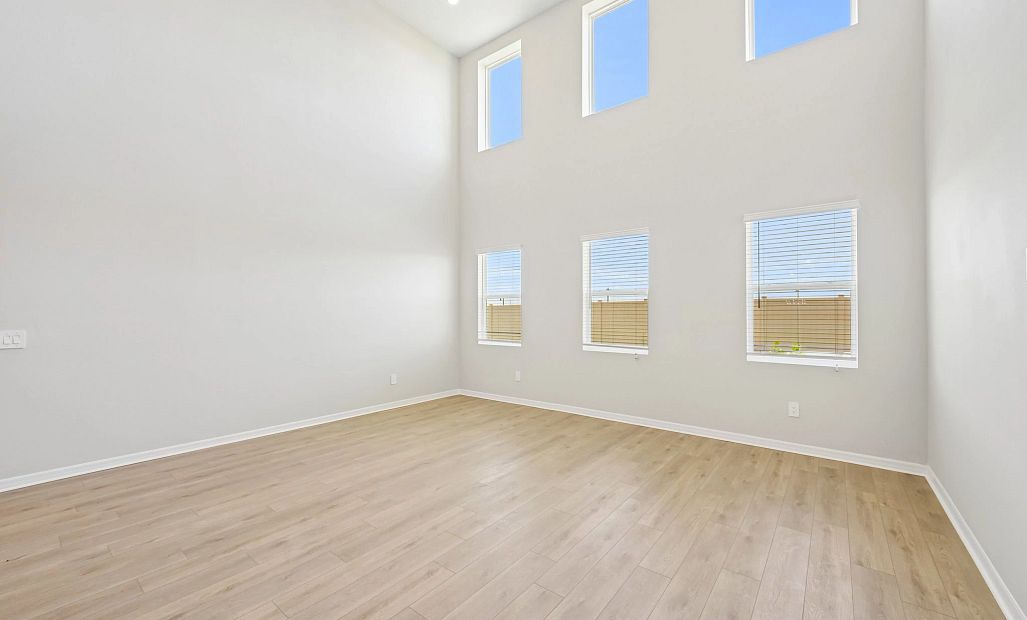 Two-story great room features six large windows for optimal lighting - Representative images and