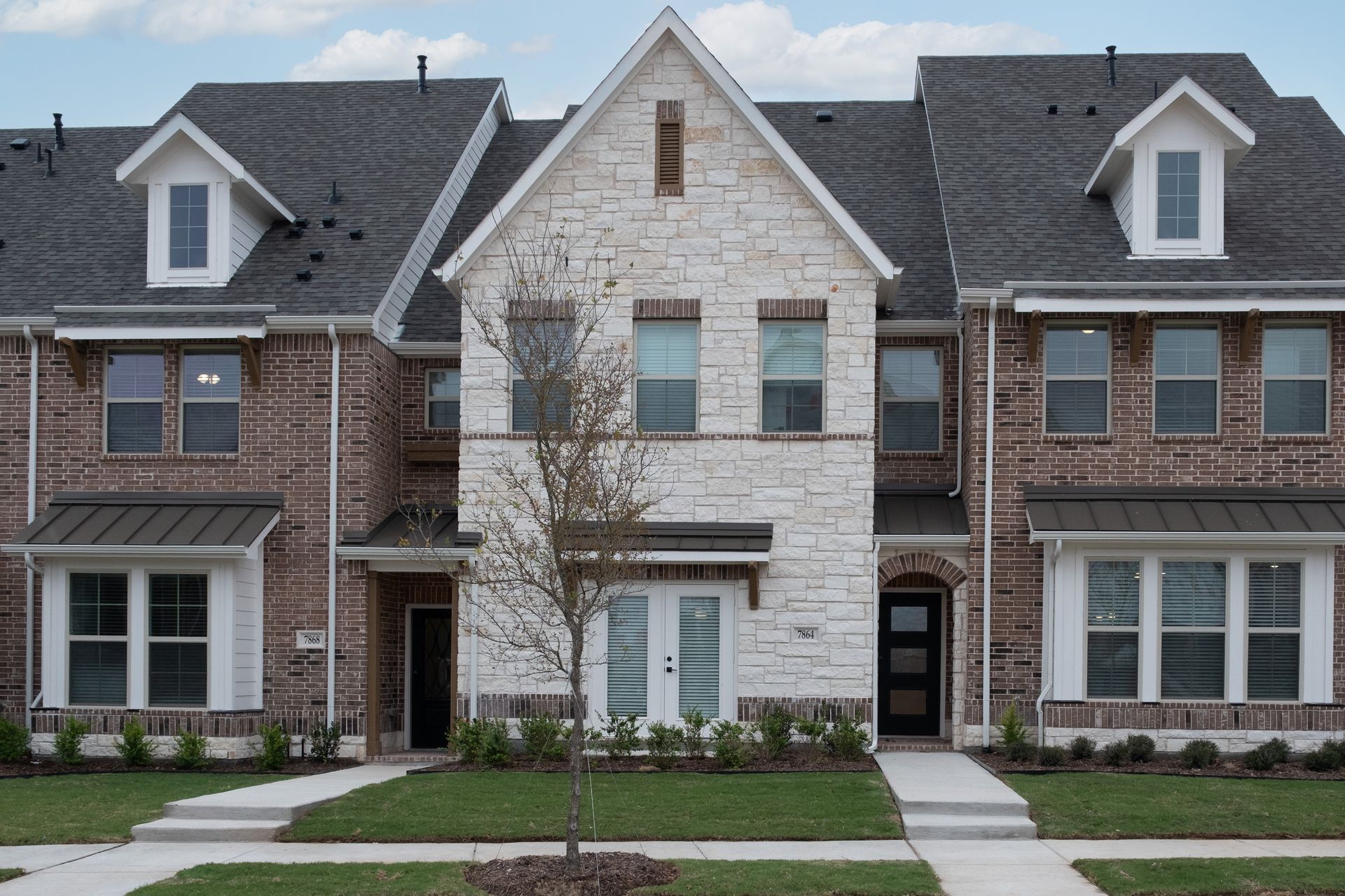 exterior of townhome with white stone
