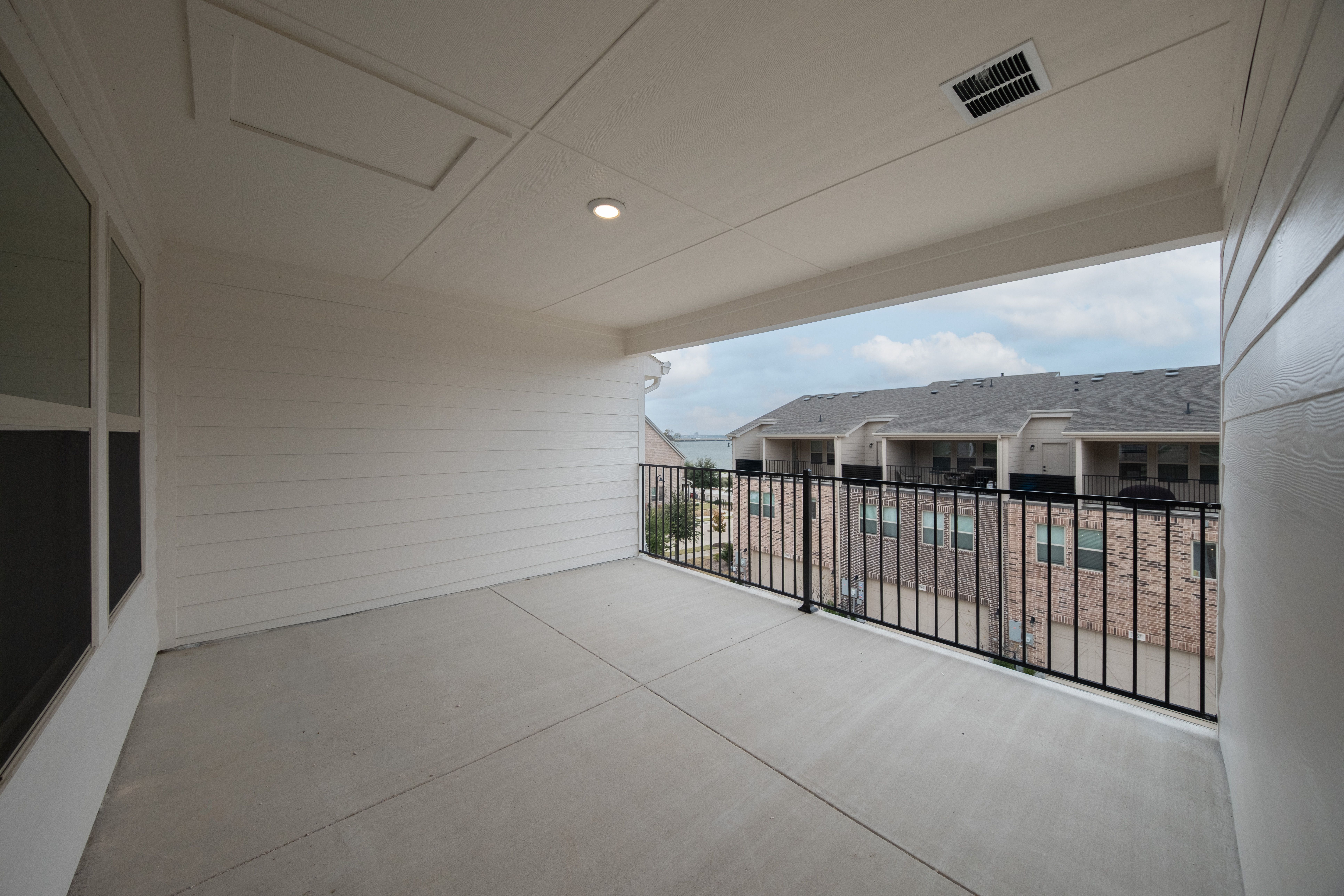 third-floor covered terrace with iron railing
