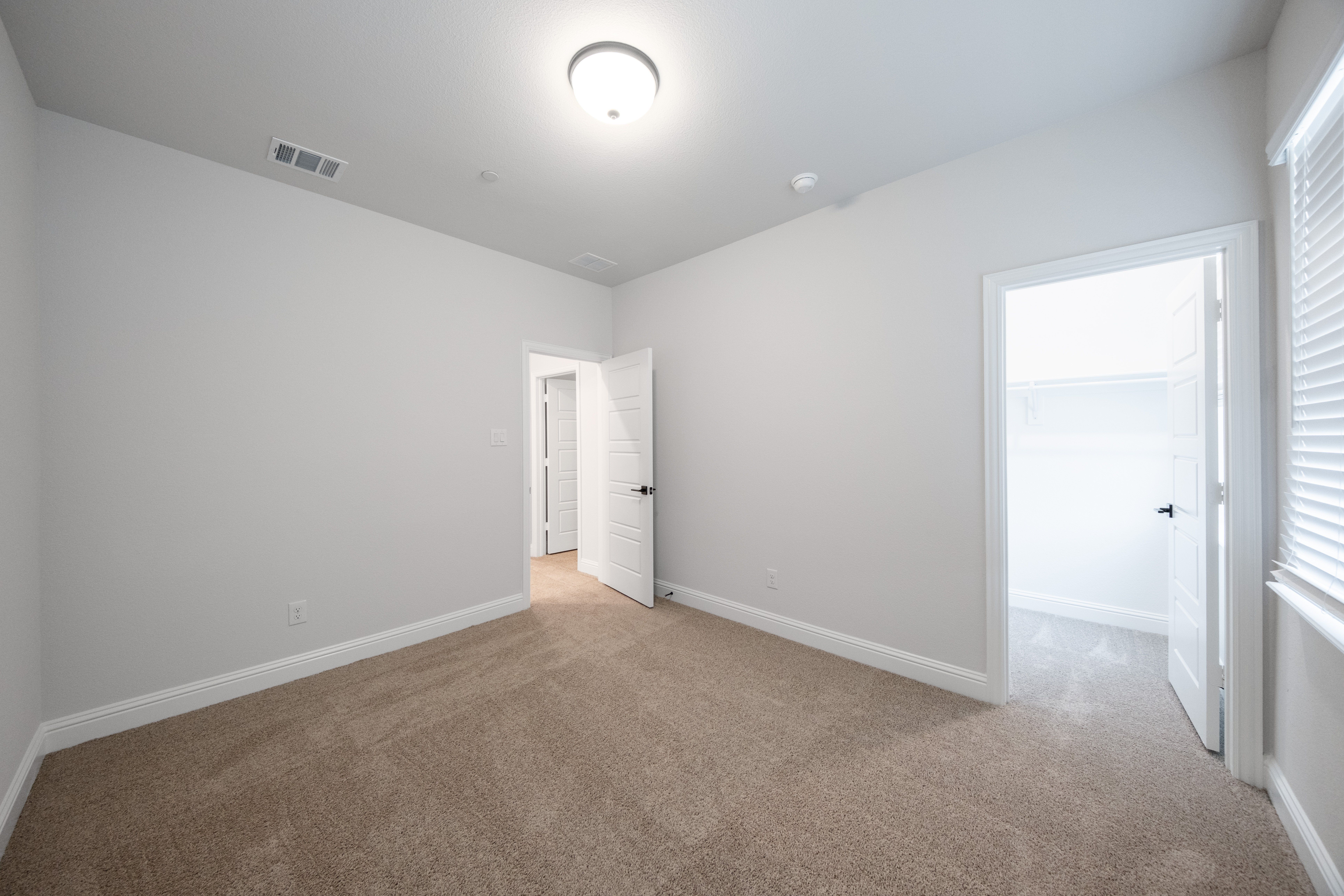 guest bedroom with carpet and window