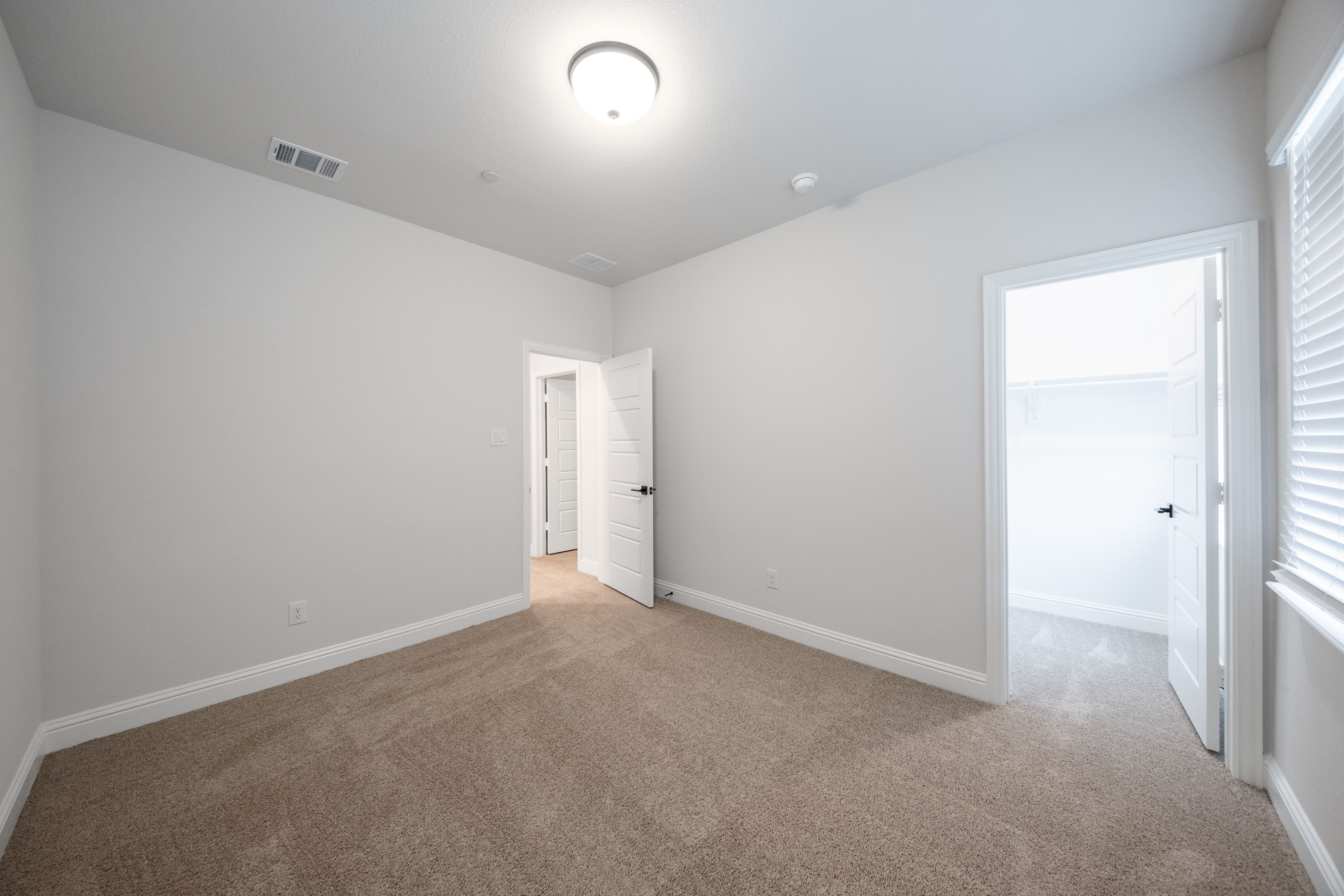 guest bedroom with carpet and window