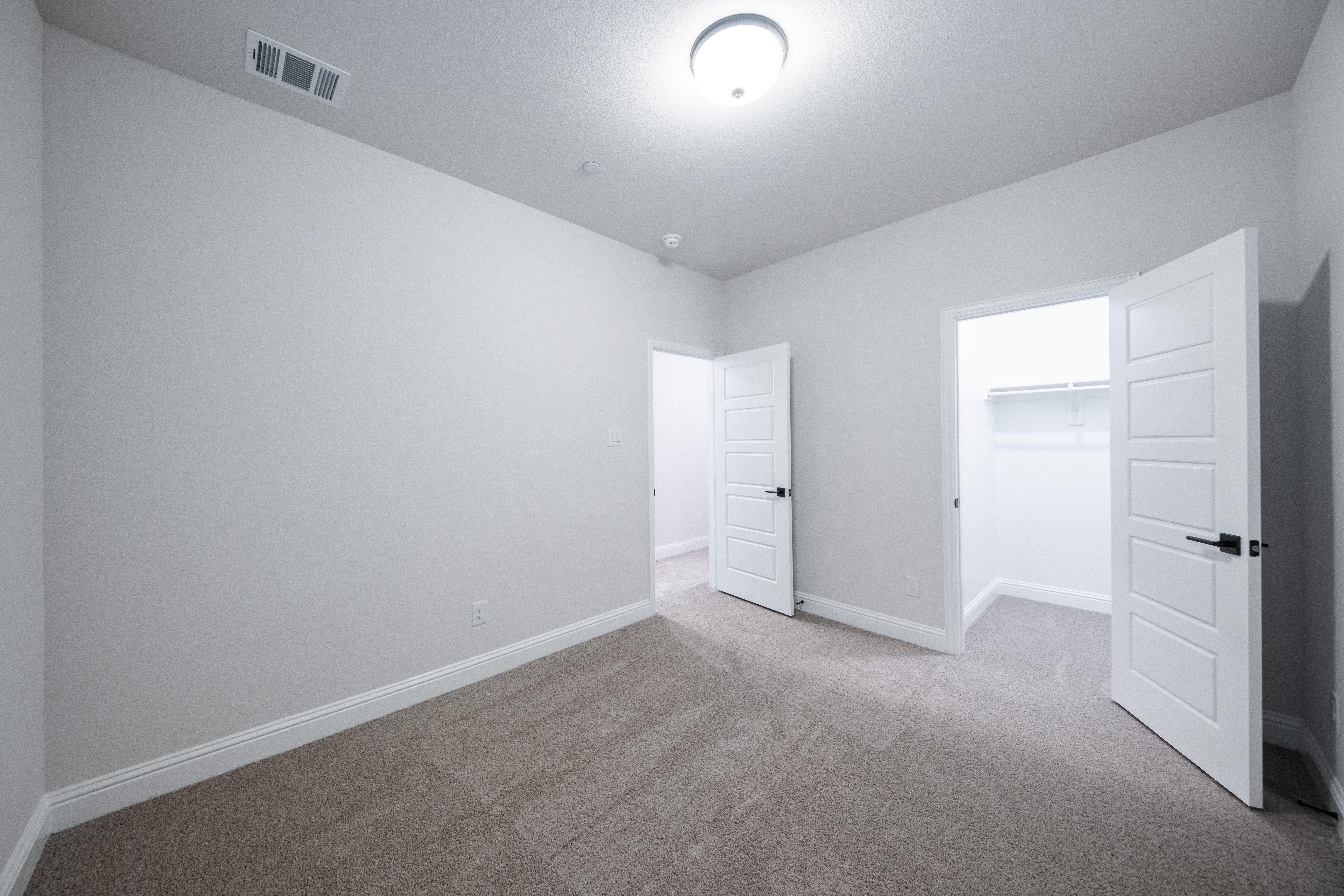 guest bedroom with carpet and window