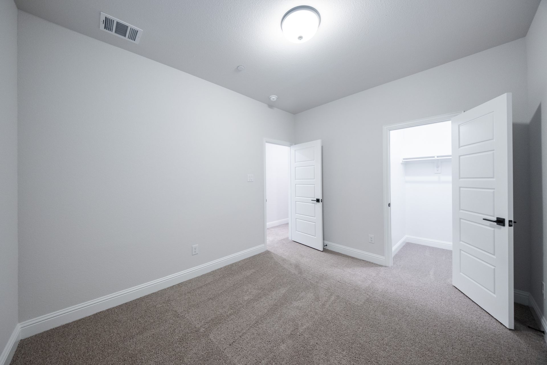 guest bedroom with carpet and window