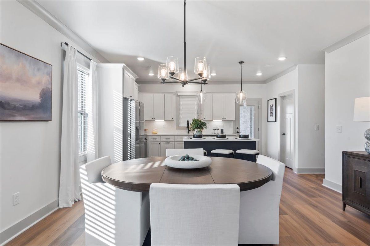 Model Dining area with beautiful dining chandelier and natural light from windows