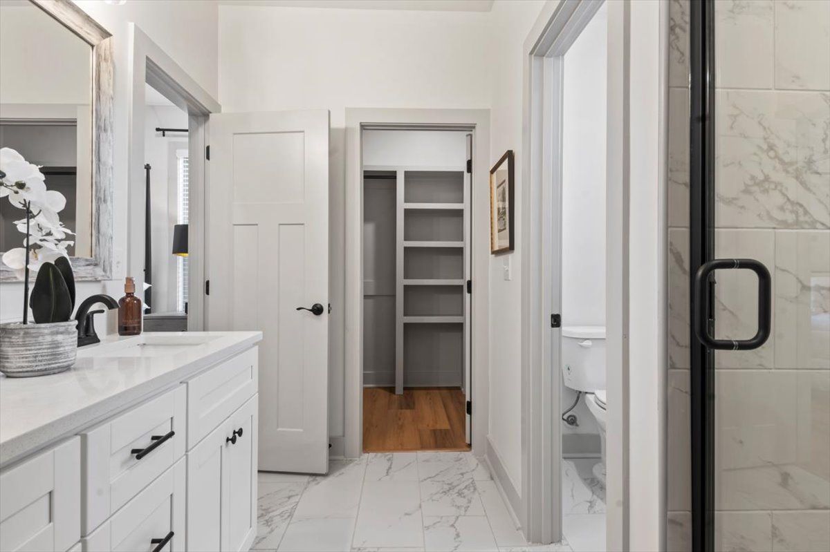Master double vanity, framed mirrors, beautiful lighting and tile flooring, built-in shelving in closet, lever door locks