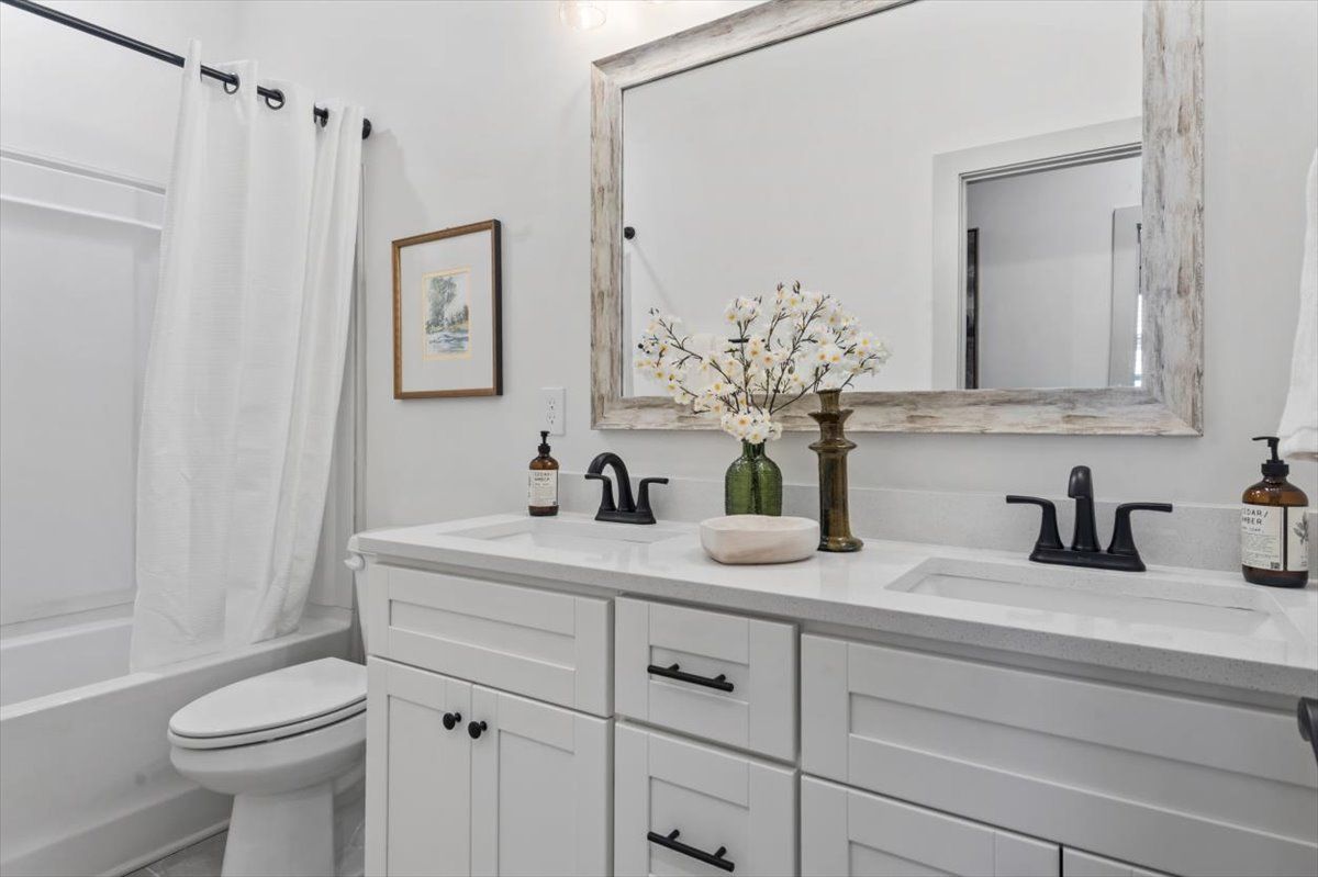 Secondary bathroom with double vanity, framed mirror, soft close drawers and doors, cabinet hardware