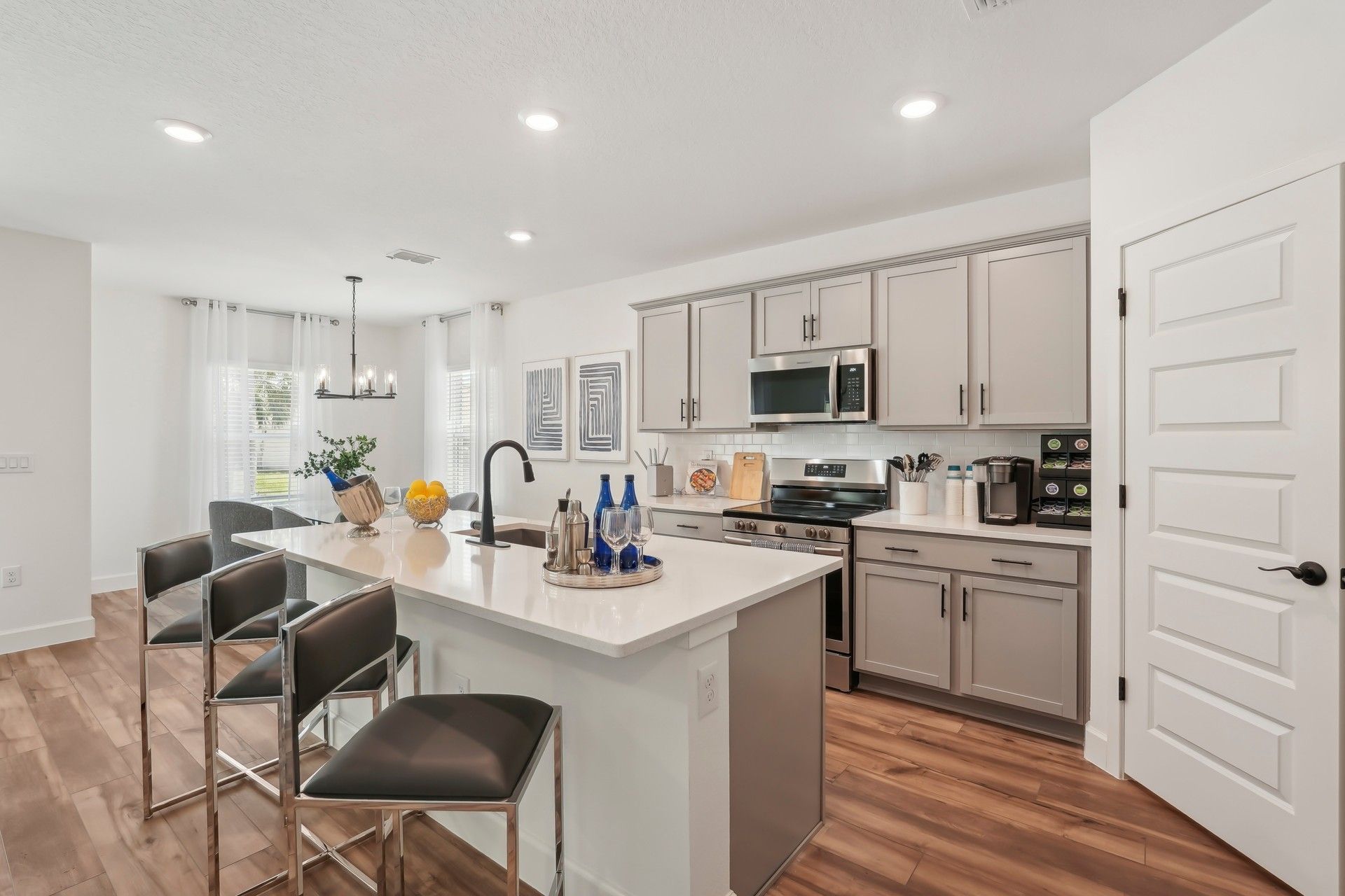 Spacious kitchen features sleek white island, elegant gray cabinetry, and premium stainless appliances in North Port.
