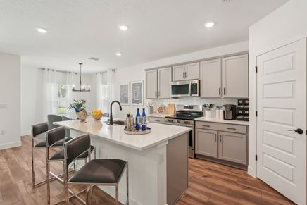 Spacious kitchen features sleek white island, elegant gray cabinetry, and premium stainless appliances in North Port.