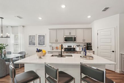 This North Port kitchen boasts quartz countertops, stainless steel appliances, and chic contemporary design.