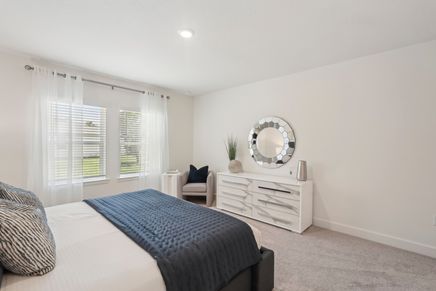 Elegant North Port bedroom with a chic round mirror and contemporary white dresser.