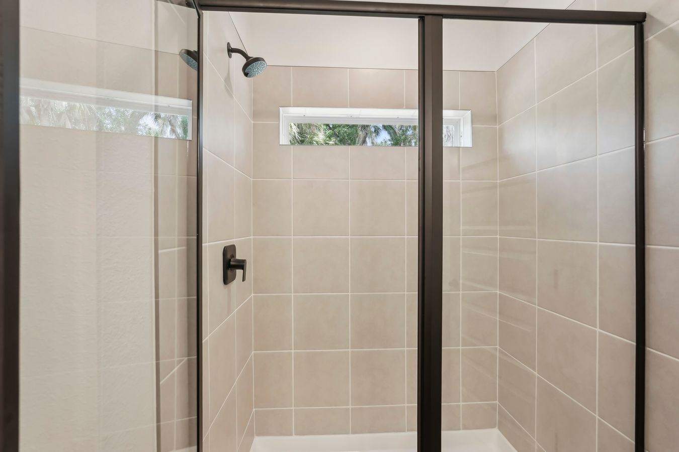 Elegant North Port shower with contemporary tiles and sleek glass enclosure.