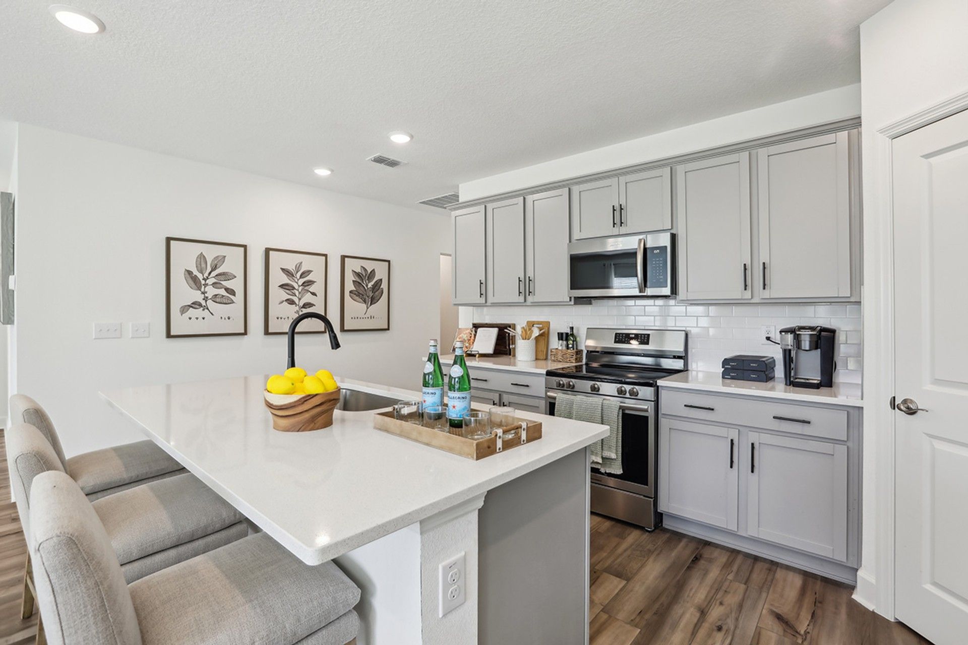 Stylish Spring Hill kitchen features gray cabinetry, sleek island, and subway tiles for a refined look.