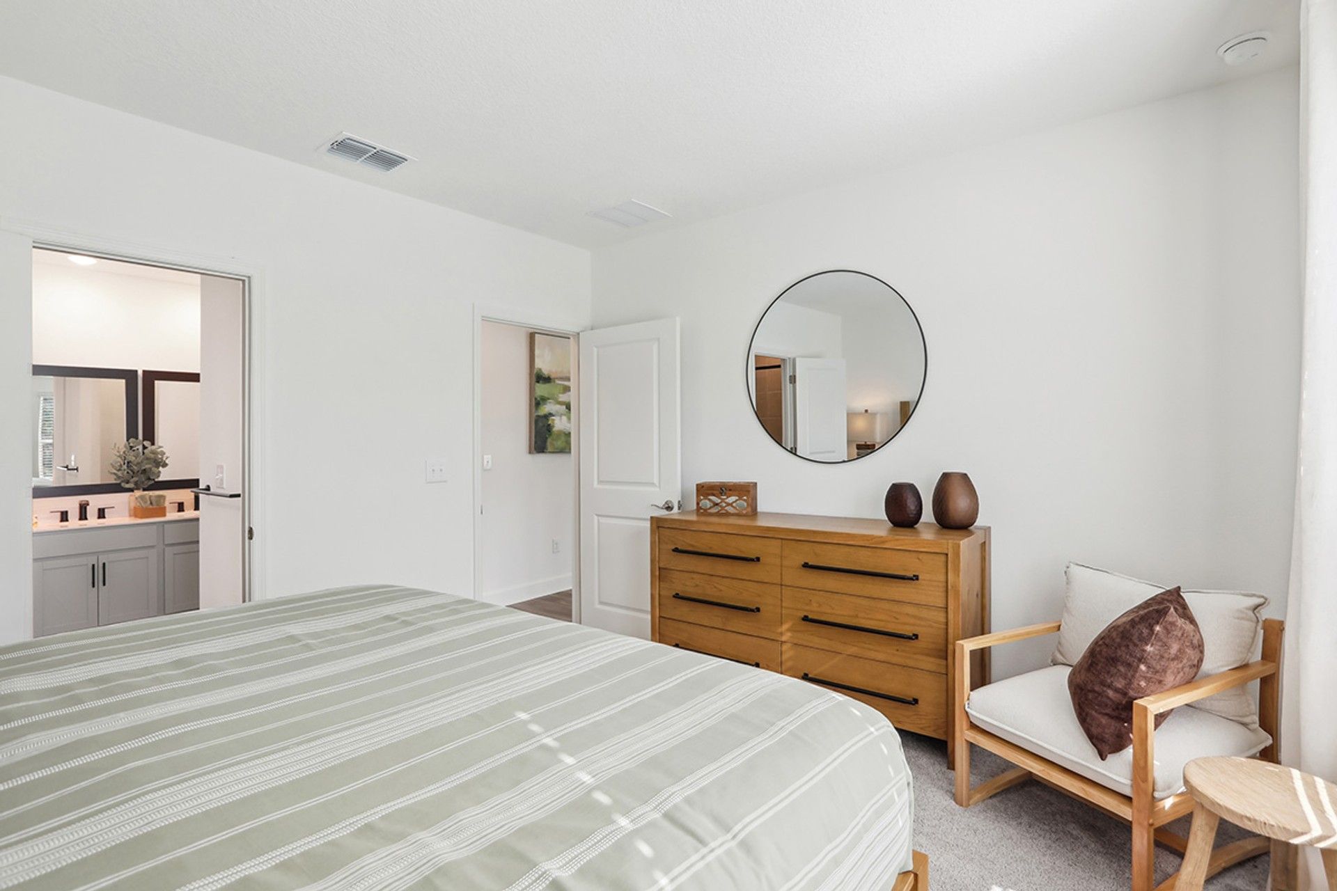 Elegant Spring Hill bedroom features a wood dresser and en-suite bathroom for luxury living.