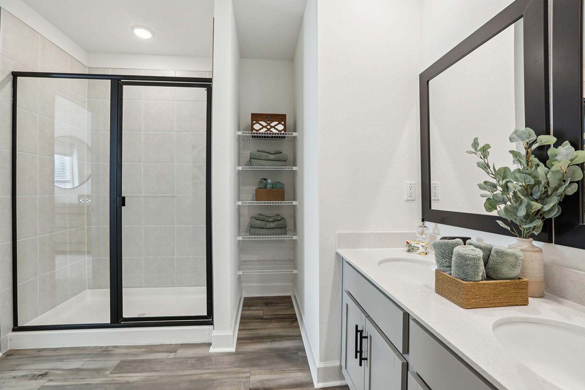Elegant Spring Hill bathroom boasts a sleek glass shower and refined wood flooring.
