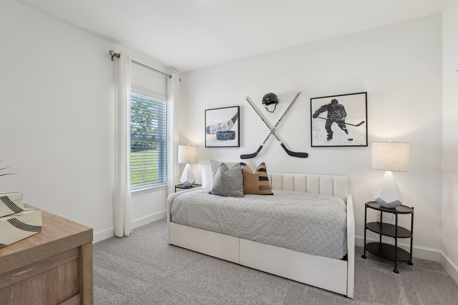 Elegant Spring Hill bedroom features hockey decor, plush carpeting, and natural light.