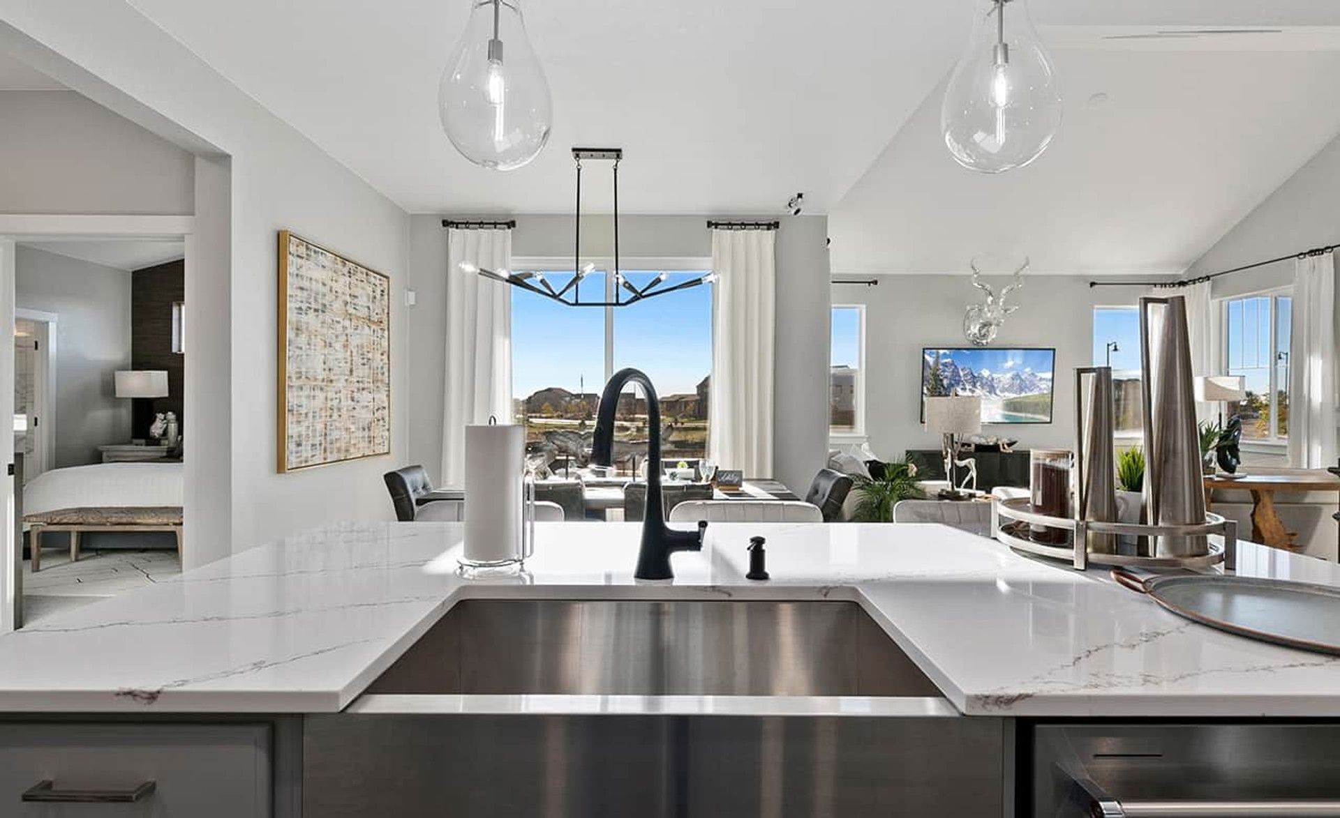 Elegantly designed kitchen features stunning marble countertops and sleek black fixtures in Trailside on Harmony.