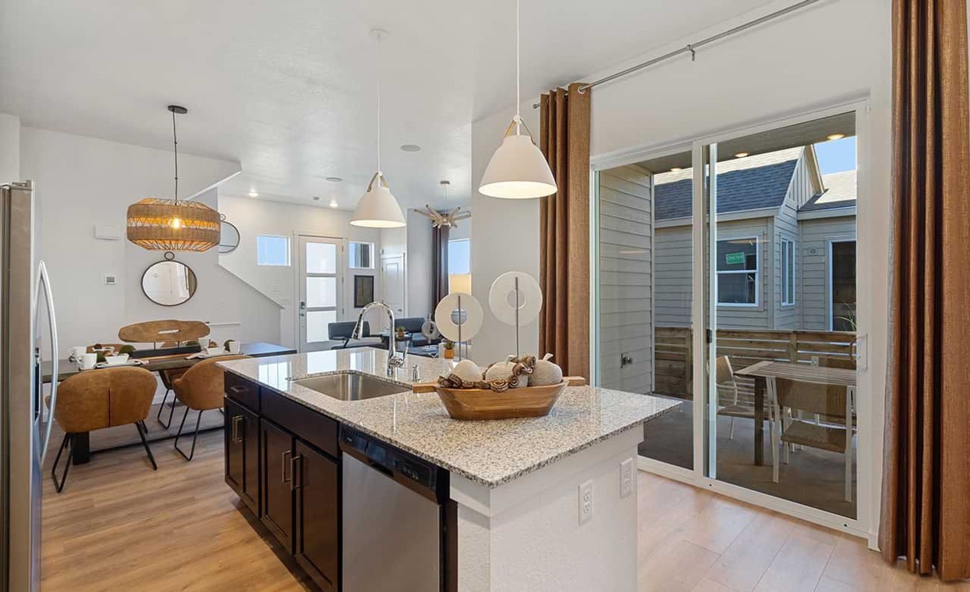 Luxurious granite island and elegant pendant lighting enhance kitchen elegance in Trailside on Harmony.