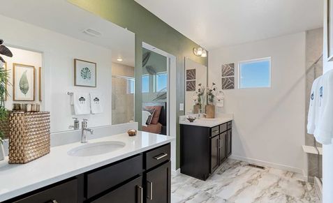 Exquisite double vanity, sleek dark wood cabinets, and elegant marble flooring in Trailside on Harmony.