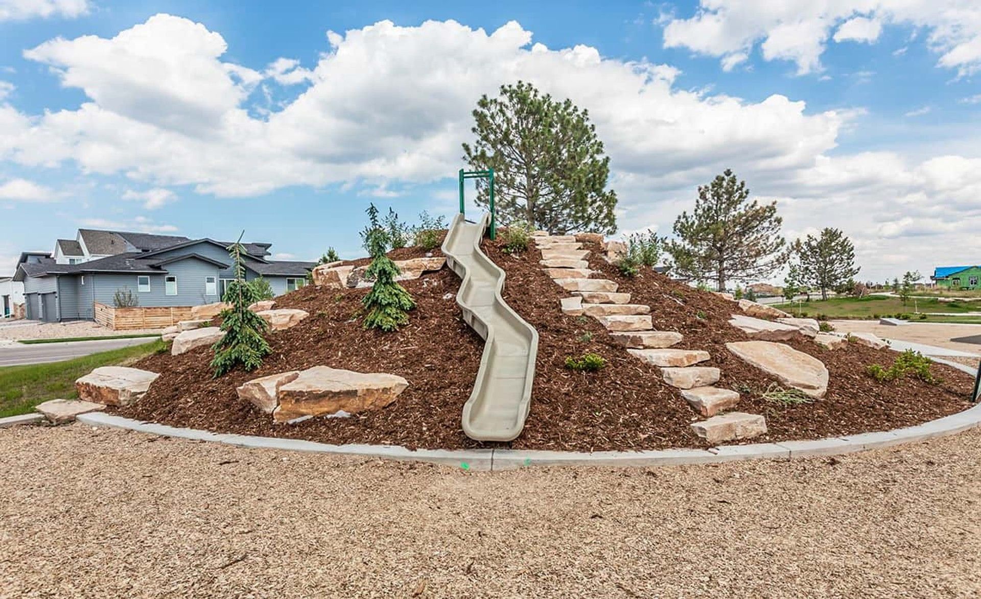 Experience Trailside on Harmony's elegant playground with a sculpted hill, stone steps, and sleek slide.