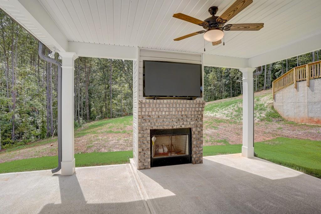 Exterior Back of Home.   View of Game Day Porch and outdoor brick fireplace. 10' x 12' Concrete Patio.  Ceiling Fan/Light and Hook up for TV. Low Maintenance Vinyl Siding.    Architectural Shingles and Aluminum Gutters.