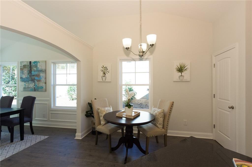Breakfast Room and Pantry with view to Dining Room.  LVP Flooring.  Upgraded Trim Package.  Arched Columns.  
