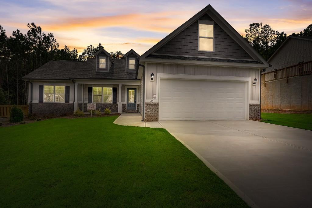 Exterior of Home.  Brick Accents and Wanes Coat on Front.  Low Maintenance Vinyl Siding.  Two coach lights.  2 Car Garage with Heavy Duty Metal Insulated Garage Door.  Architectural Shingles, Sprinkler System, and Aluminum Gutters.