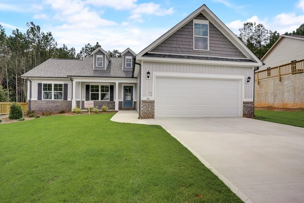 Exterior of Home.  Brick Accents and Wanes Coat on Front.  Low Maintenance Vinyl Siding.  Two coach lights.  2 Car Garage with Heavy Duty Metal Insulated Garage Door.  Architectural Shingles, Sprinkler System, and Aluminum Gutters.