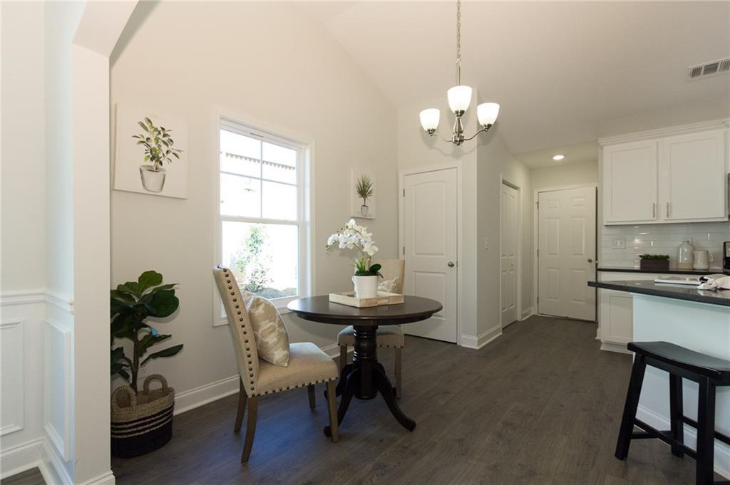 Breakfast Room and Pantry with view to door to Garage.  LVP Flooring.  Arched Columns.  
