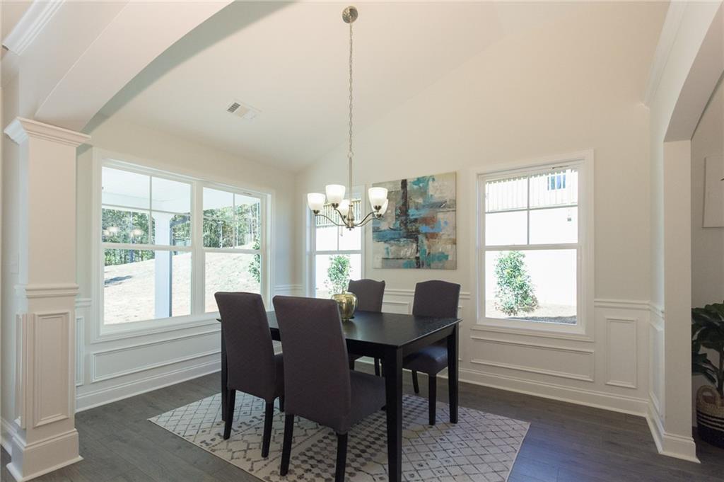 Dining Room with Vaulted Textured California Ceiling.  Upgraded Trim Package and LVP flooring.  Arched Columns.