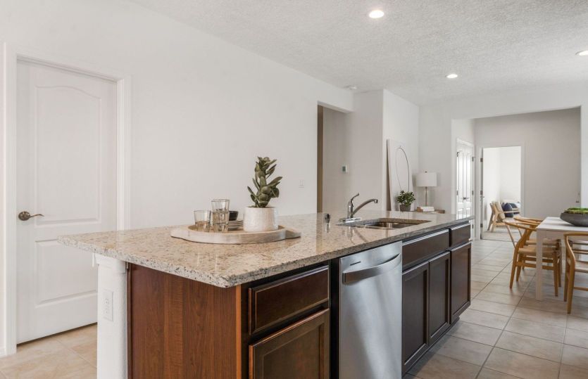 Granite kitchen island with built-in outlet and stainless steel dishwasher