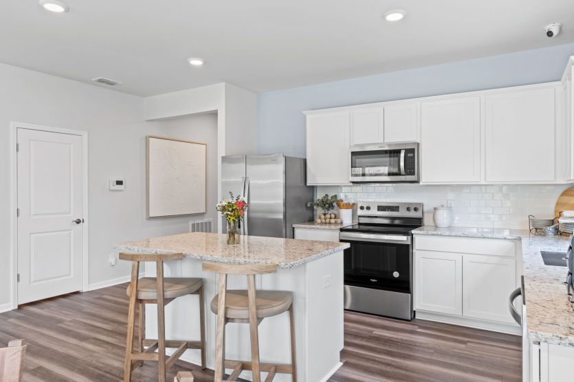 Additional seating at Kitchen Island. Model Home Representation.
