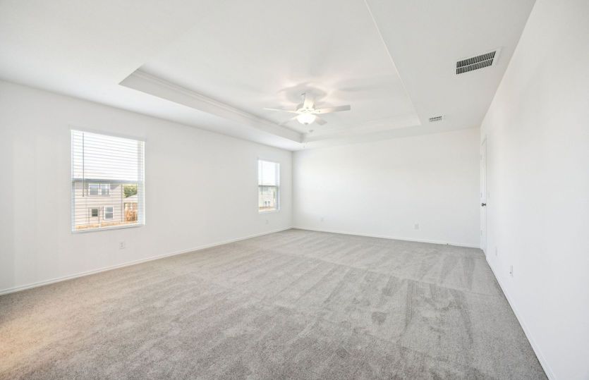 Owner's suite with tray ceiling and large windows *photos are not of actual home, some features vary