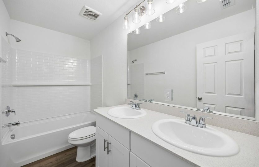 Secondary bath with double vanity and tile surrounded shower *model representation